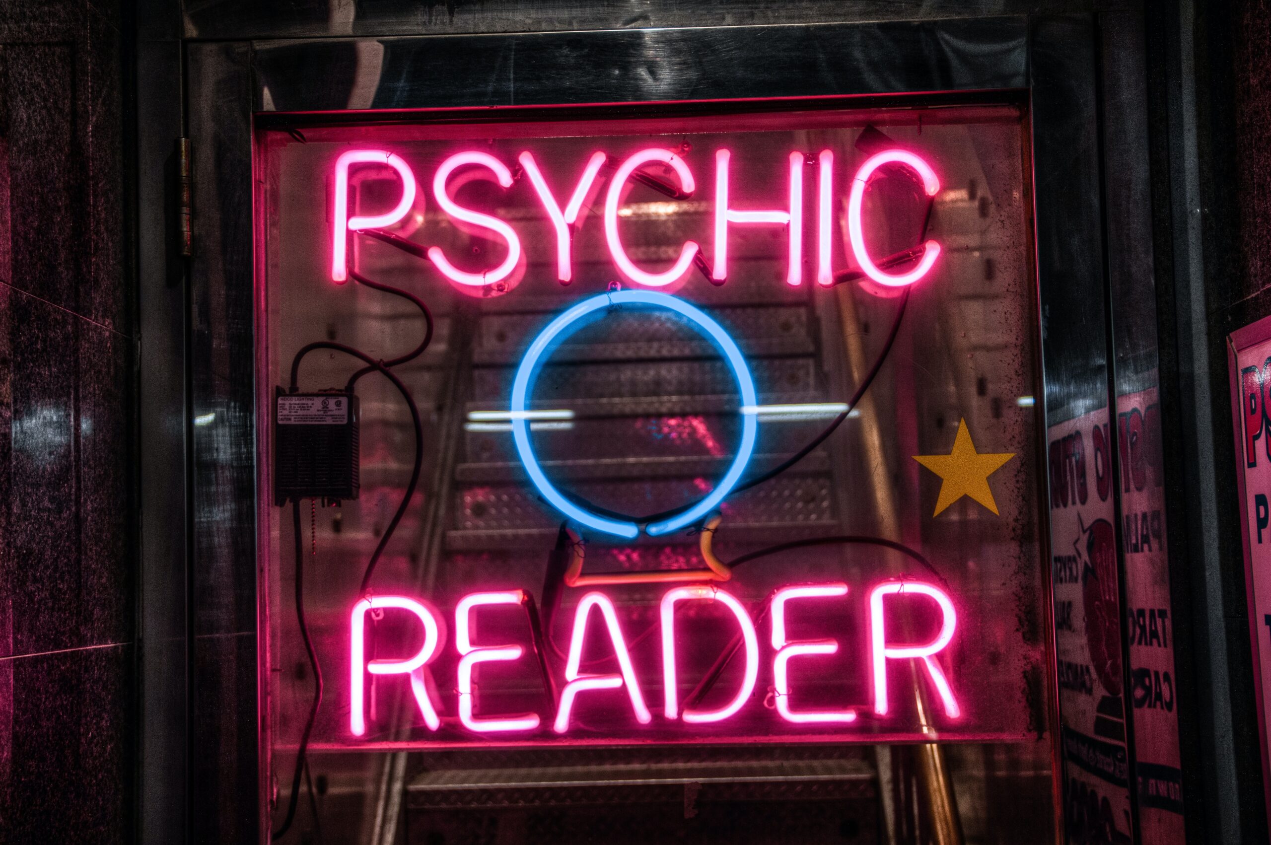 Neon sign saying 'psychic reader'